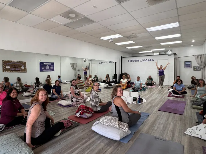Members settled on mats and cushions across the studio floor