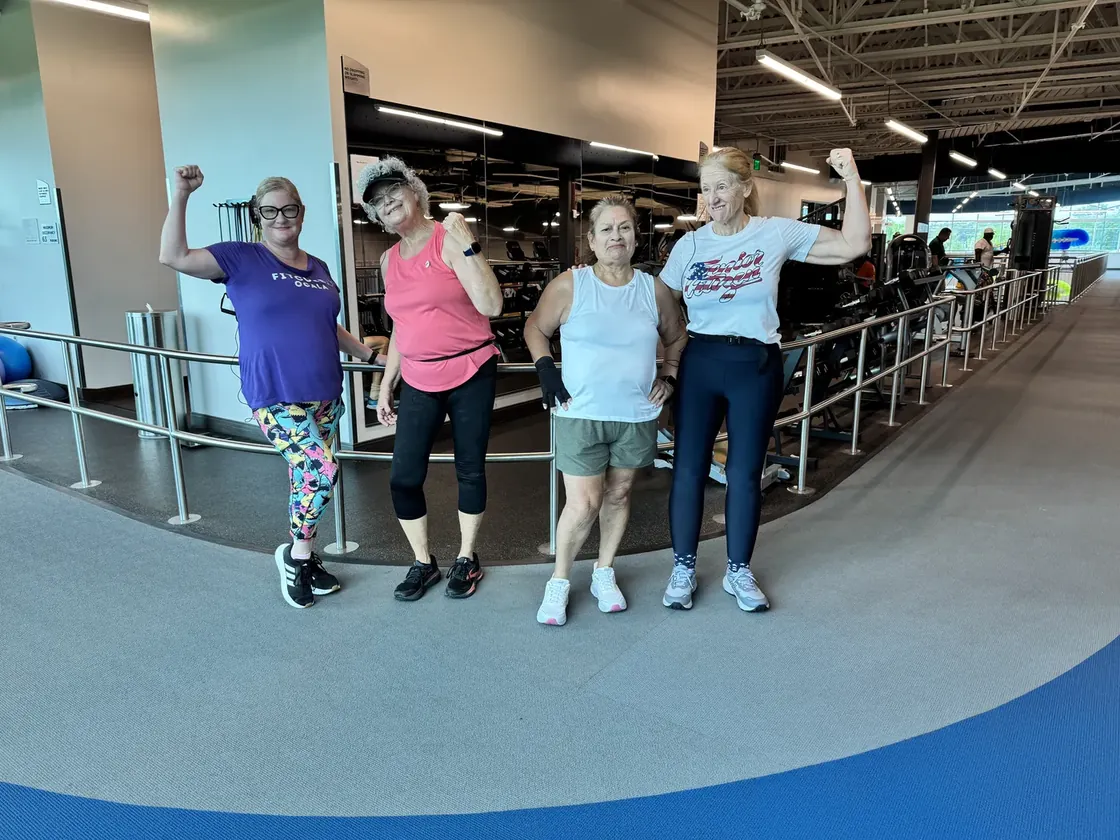 Four Strutercize walkers flexing on an indoor walking track