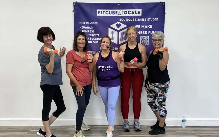 Five members with hand weights under the FitCube banner